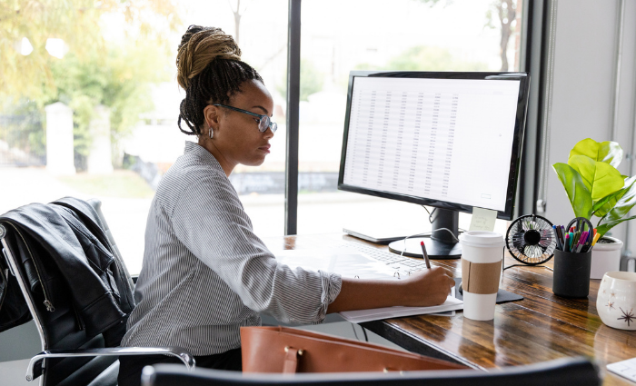A mid adult African American businesswoman concentrates while working in her office.